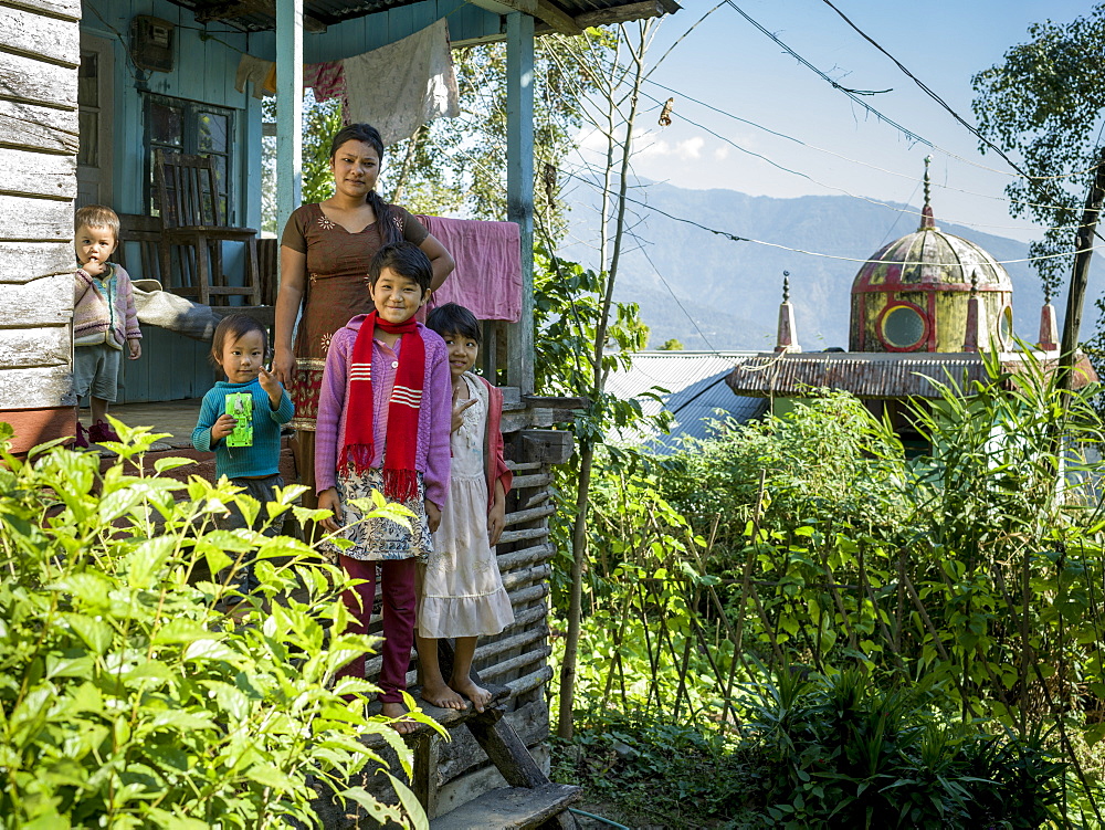 A mother with four children standing on the steps of their home near the Glenburn Tea Estate, West Bengal, India