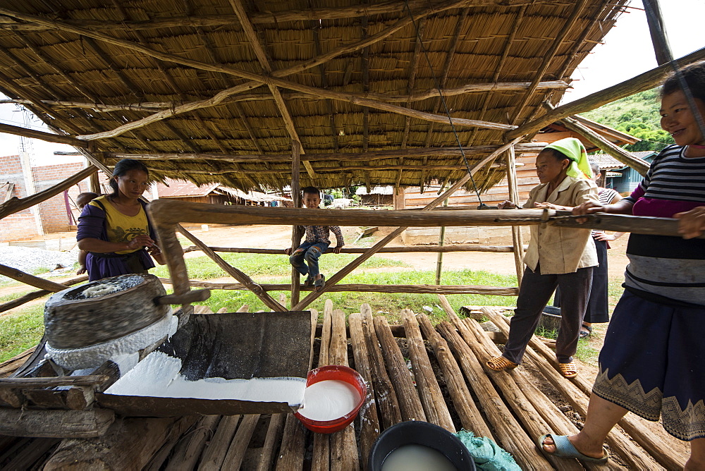 Hmong women grinding rice for the production of rice paper in Na Kam Peng, also called Bomb Village, Xiangkhouang, Laos