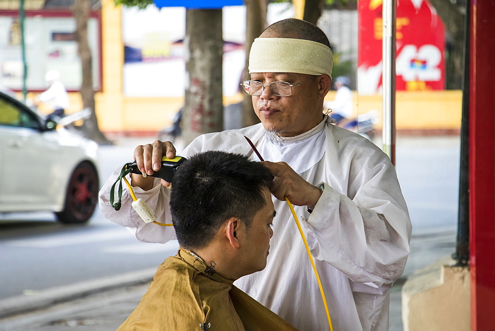 Street barber giving a haircut in the Old Quarter, Hanoi, Hanoi, Vietnam