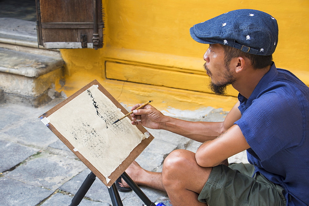 Man painting on the street in the Old Quarter, Hoi An, Quang Nam, Vietnam