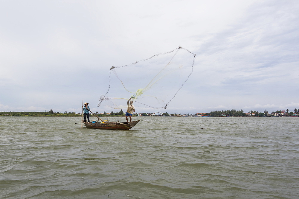 Fisherman throwing a net from a boat, Hoi An Ancient Town, Quang Nam, Vietnam