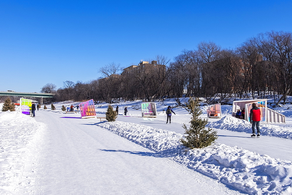 People walking and skating along the Red River Mutual Trail in Winnipeg, where artistic warming huts are on display, Winnipeg, Manitoba, Canada