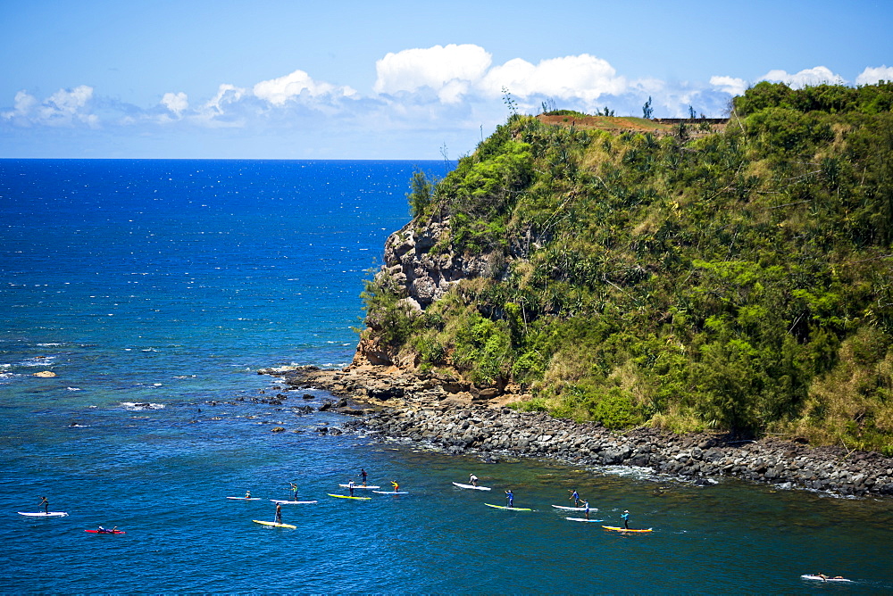 Group of paddler boarders and stand up paddle boarders, paddling from Maliko for a coast run on the North shore of Maui, Paia, Maui, Hawaii, United States of America