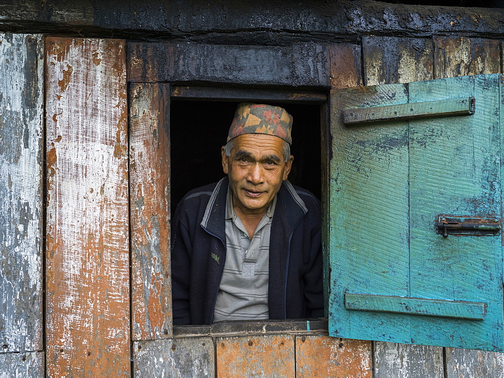 Portrait of an Indian man looking out a window, Radhu Khandu Village, Sikkim, India