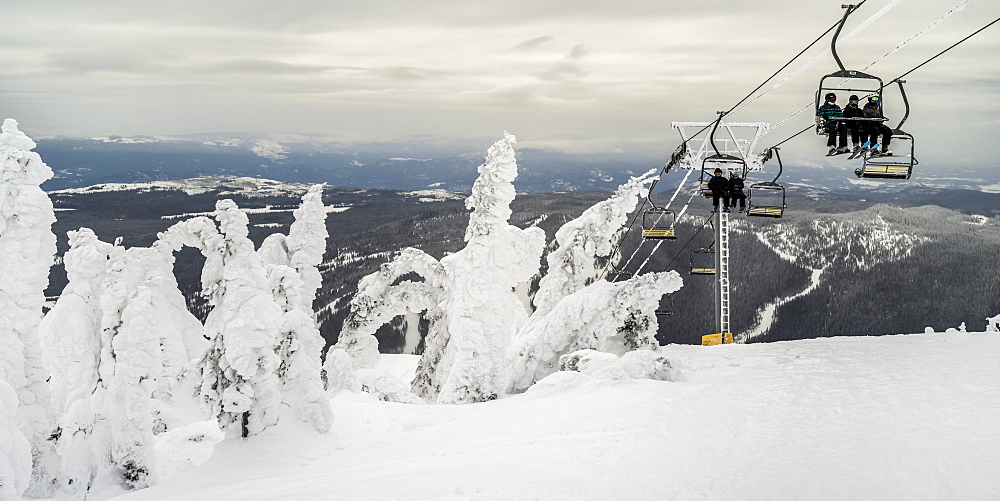 Skiers on a chairlift at Sun Peaks ski resort, Kamloops, British Columbia, Canada