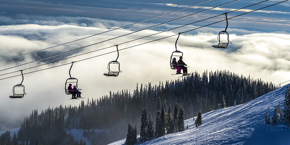 Skiers on a chairlift at Sun Peaks ski resort, Kamloops, British Columbia, Canada