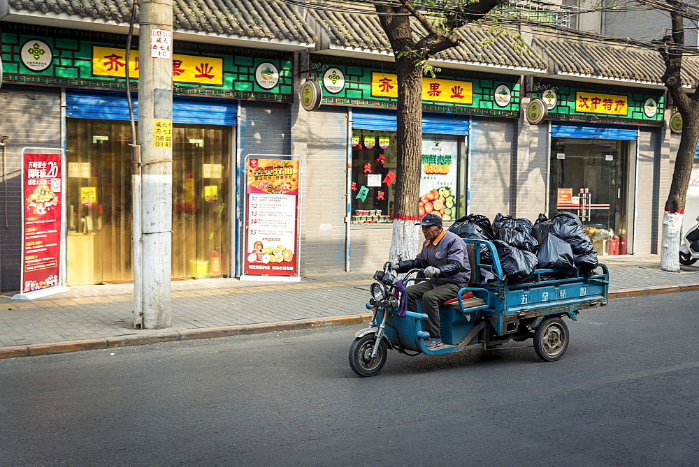 Vehicle carrying big, black plastic bags, Xian, Shaanxi Province, China