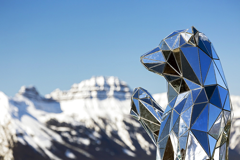 Close-up of mirrored bear sculpture with snow-covered mountain and blue sky in the background, Banff National Park, Banff, Alberta, Canada