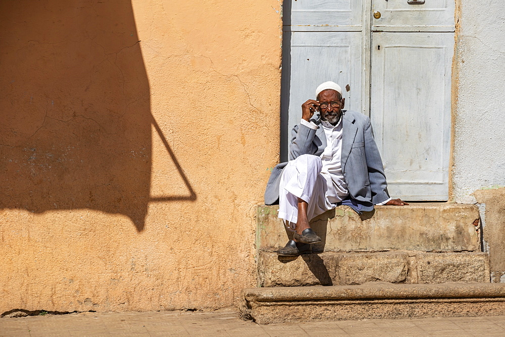 Eritrean man sitting on steps outside a door, Asmara, Central Region, Eritrea