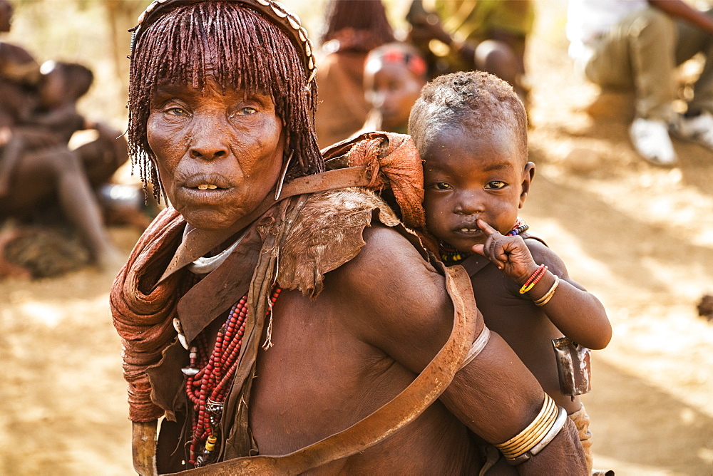 Hamer woman carrying a baby at a bull jumping ceremony, which initiates a boy into manhood, in the village of Asile, Omo Valley, Southern Nations Nationalities and Peoples' Region, Ethiopia