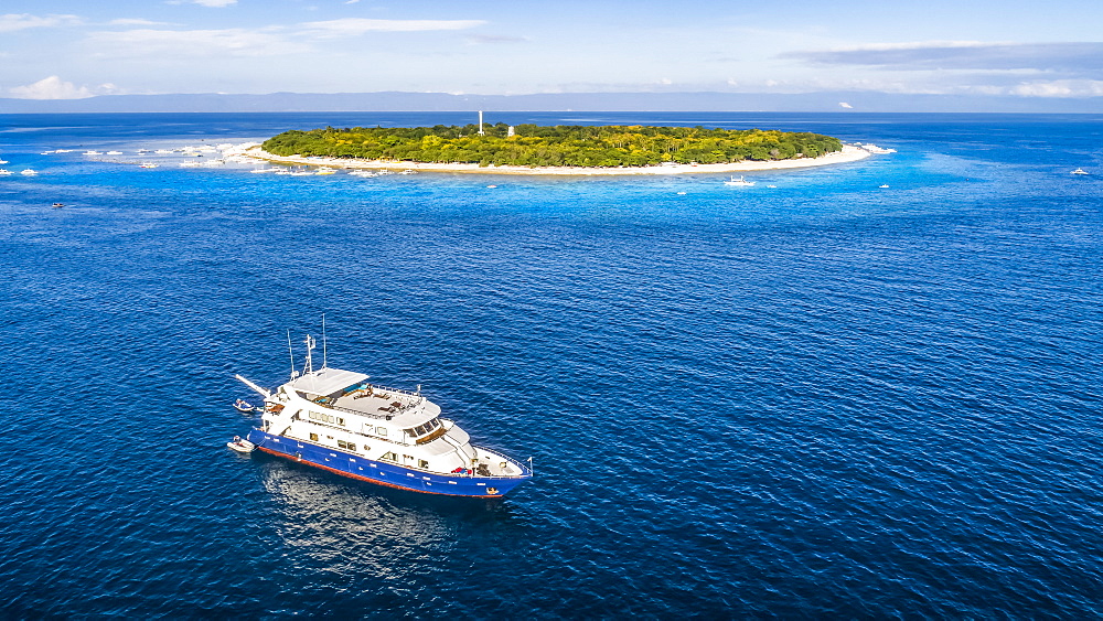 An aerial view of the live aboard vessel Infiniti for scuba diving off Balicasag Island, a tiny island in South West Bohol in the central Philippines. It is famous for scuba diving on the deep, vertical walls and there are some fantastic hard coral gardens at snorkeling depths, Balicasag Island, Philippines