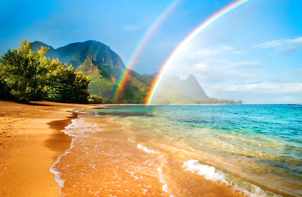 A double rainbow over the coastline of a Hawaiian island with mountains and turquoise water, Haena, Kauai, Hawaii, United States of America