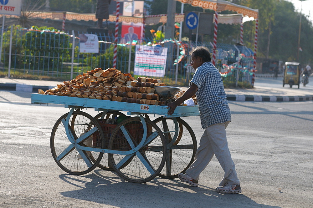 Selling varieties of bread on a push cart, Gujarat, India, Asia