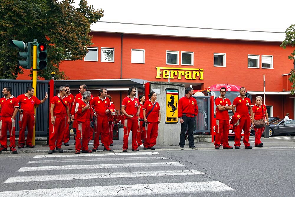 Workers leave Ferrari Factory, with entrance and sign in background, Maranello, Emilia-Romagna, Italy, Europe