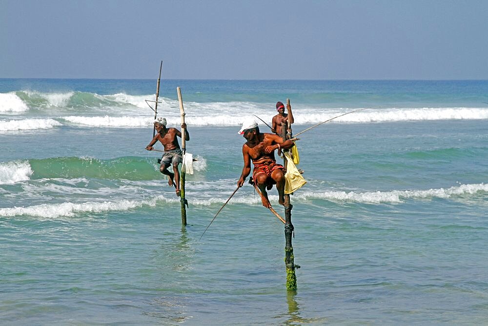 Stilt fishermen and Indian Ocean, Weligama, Sri Lanka, Asia