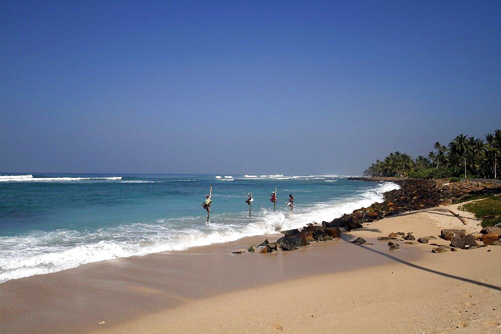 Stilt fishermen and Indian Ocean, Midigama, Sri Lanka, Asia