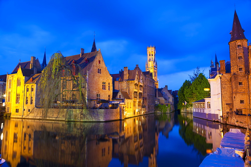 The Belfry and buildings lit up at night along a Canal in the historic center of Bruges, UNESCO World Heritage Site, Belgium, Europe