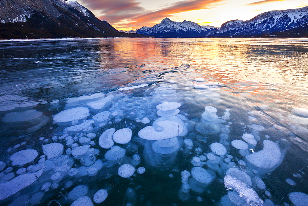 Bubbles and Cracks in the Ice with Elliot Peak in the Background at Sunset, Abraham Lake, Alberta, Canada, North America