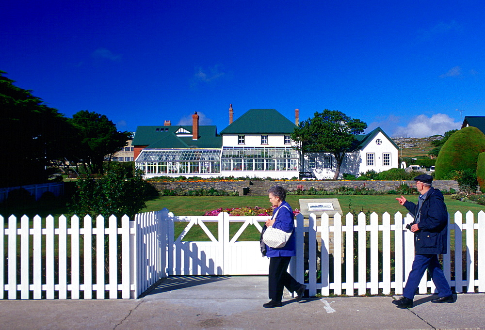 People walking past Government House in Port Stanley, Falkland Islands