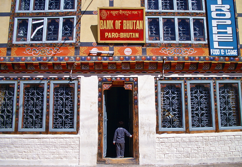 Small child standing in the doorway of the bank in Paro, Bhutan