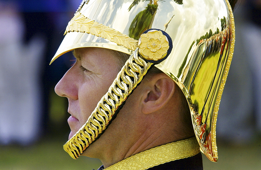 Man wears a brass helmet with chain chin strap,England