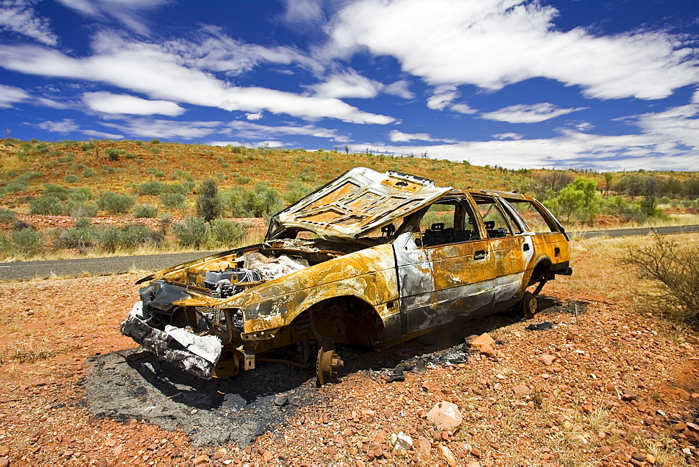 Burnt-out car wreck on road from Alice Springs, Namatjira Drive, Northern Territory, Australia