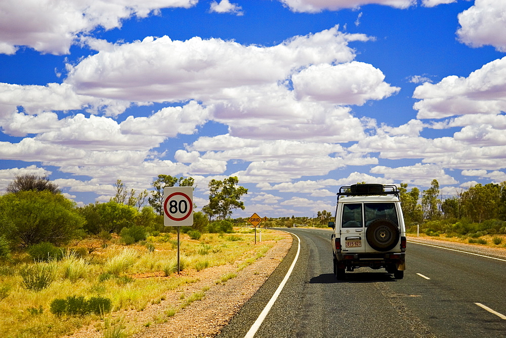 Four-wheel-drive vehicle on road in the Red Centre, Northern Territory, Australia