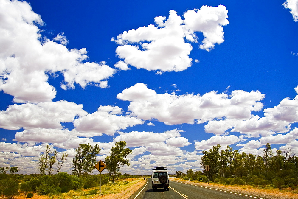 Four-wheel-drive vehicle on road in the Red Centre, Australia