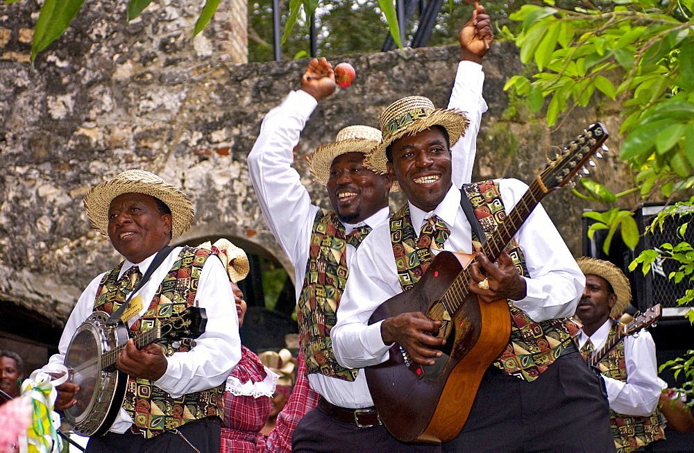 Muscians, playing guitar, banjo and maracas, in reggae style at cultural display in Montego Bay, Jamaica