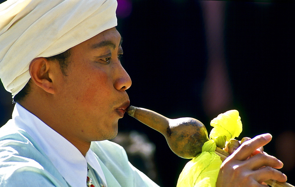 Man plays musical instrument, Kunming, China.