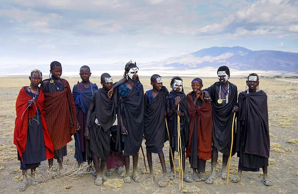 Young recently circumcised Masai Warriors (moran) with traditional face paint after 'coming of age',  and  young Masai girls,  in the Serengei Plains, Tanzania .