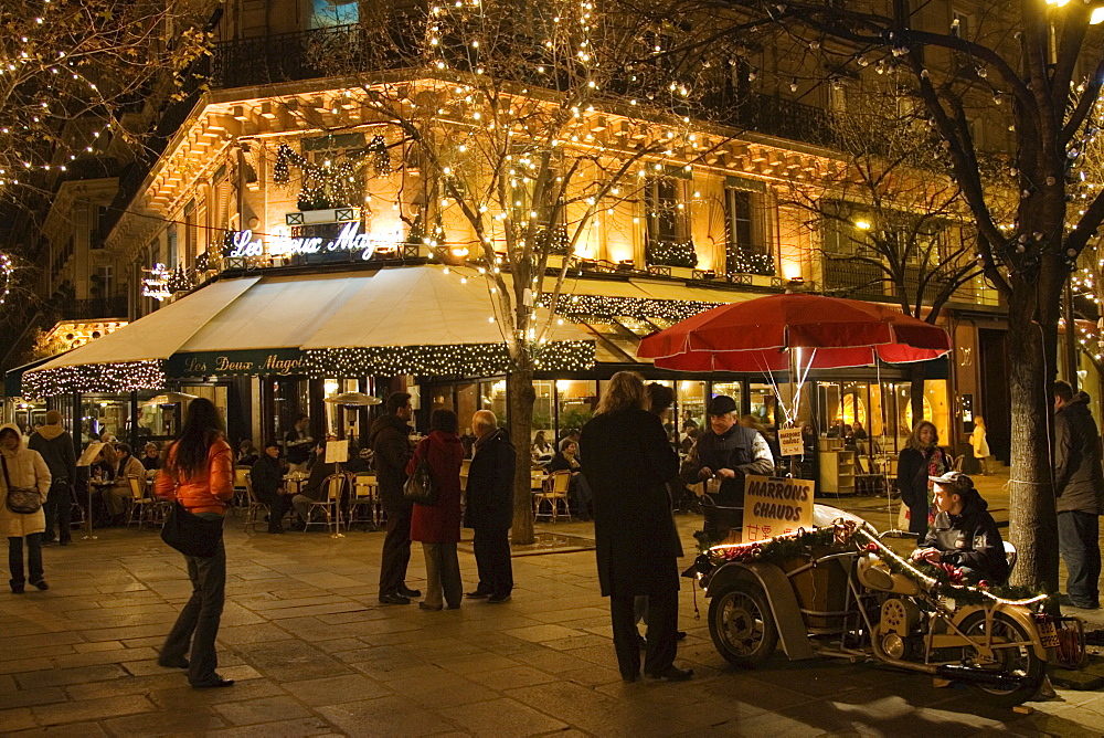 Roasted chestnut street seller outside Les Deux Magots Cafe and Restaurant, Boulevard St Germain, Paris, France