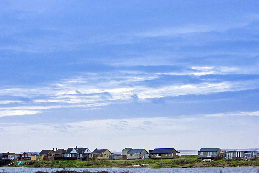 Holiday cottages along The Wash estuary in Snettisham, North Norfolk coast, East Anglia, England, United Kingdom