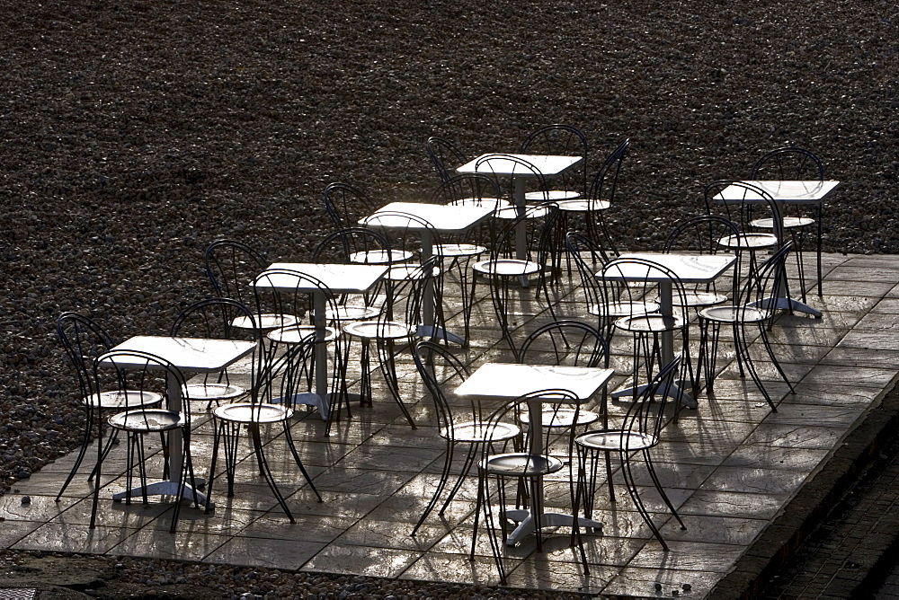 Deserted tables and chairs out of season on Brighton beach, South Coast,  England, United Kingdom