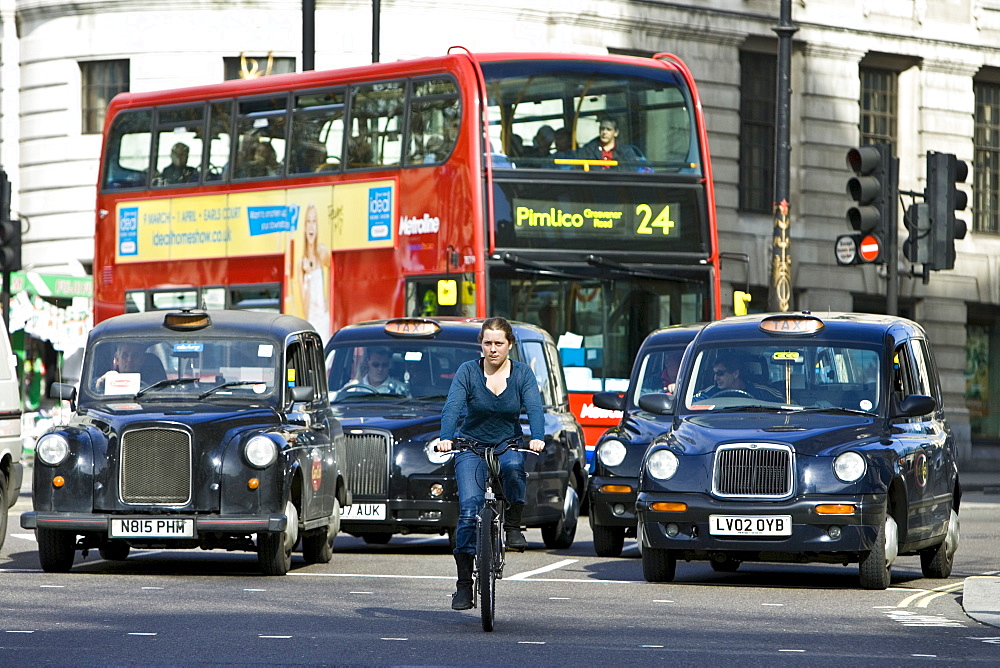 Biker in front of heavy traffic in Trafalgar Square, downtown London city centre, England, United Kingdom