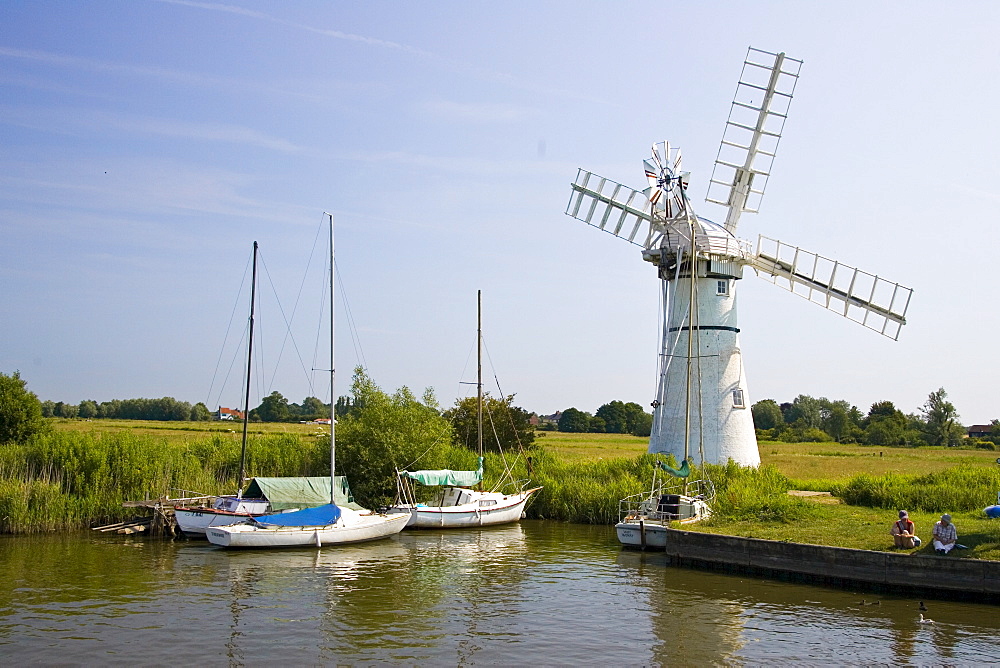 Windmill and moored sailing boats on the Norfolk Broads, United Kingdom