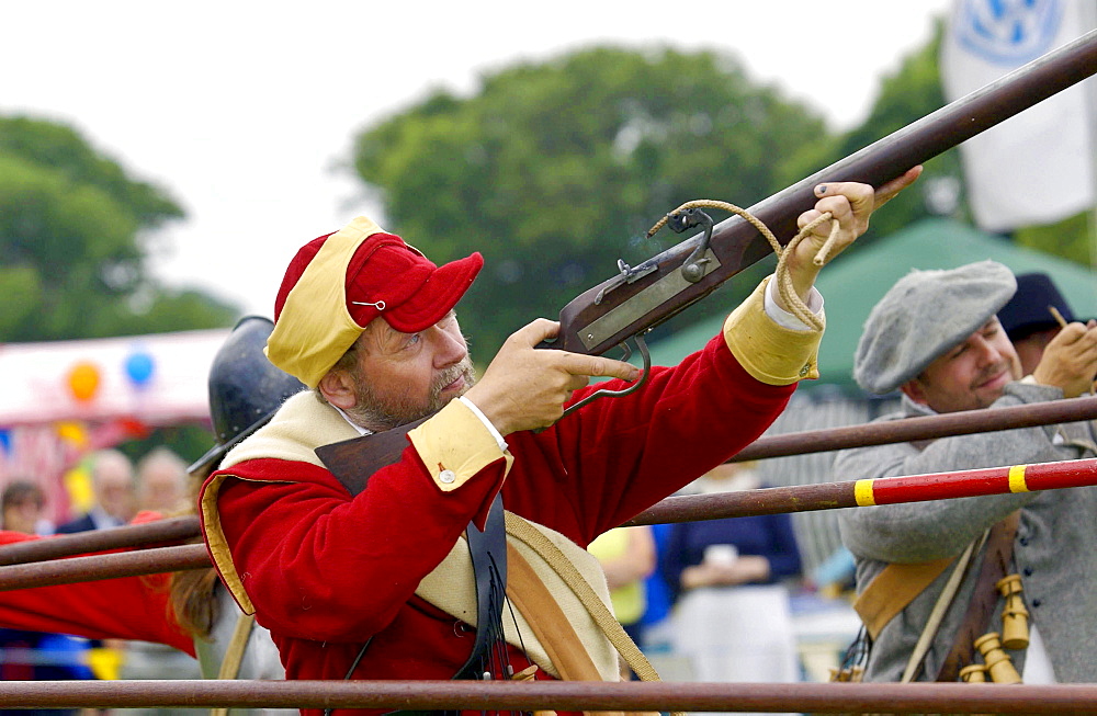 Member of the foot regiment of the sealed knot society firing a musket in the isle of man