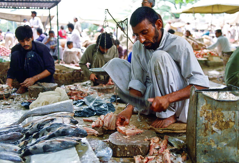 Fishmongers gutting fish ready to sell in the fish markets, Islamabad, Pakistan