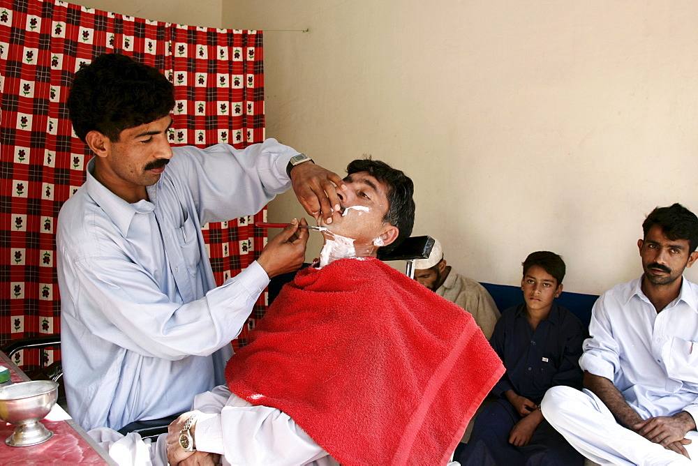 Man visits barber shop in village of Pattika, Pakistan