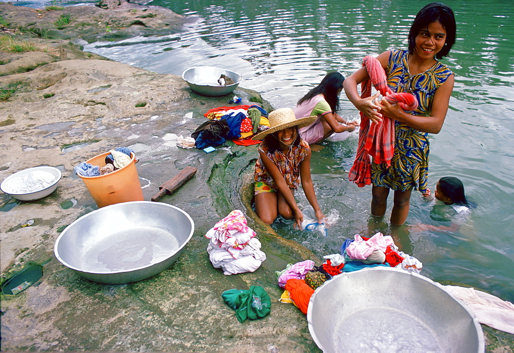 Girls washing clothes in a river, Philippines