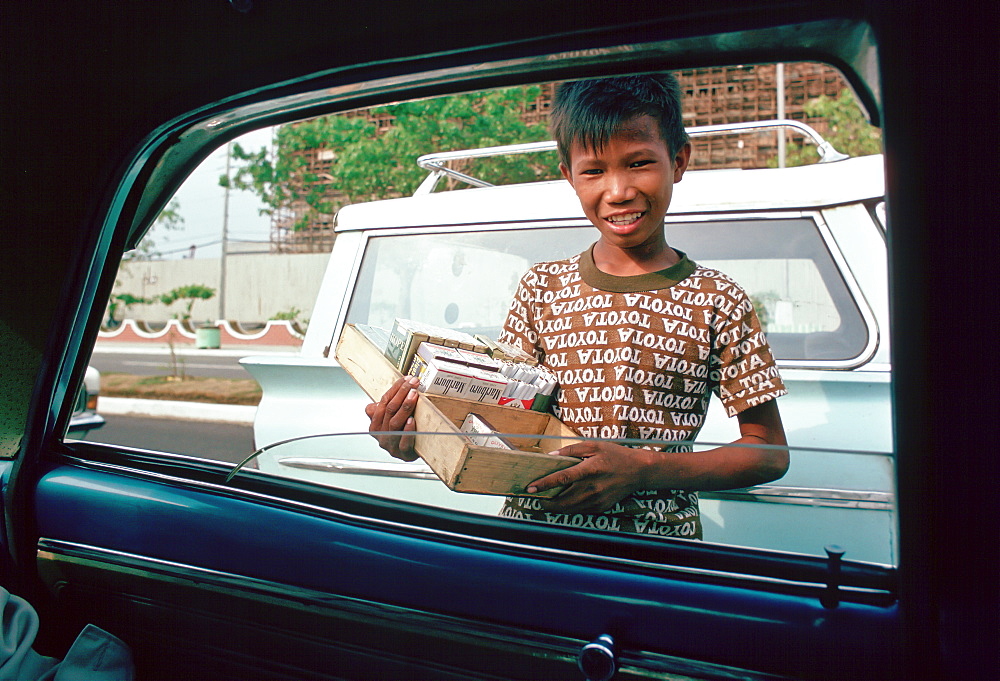 Boy sells cigarettes at car windows in Manila, Philippines