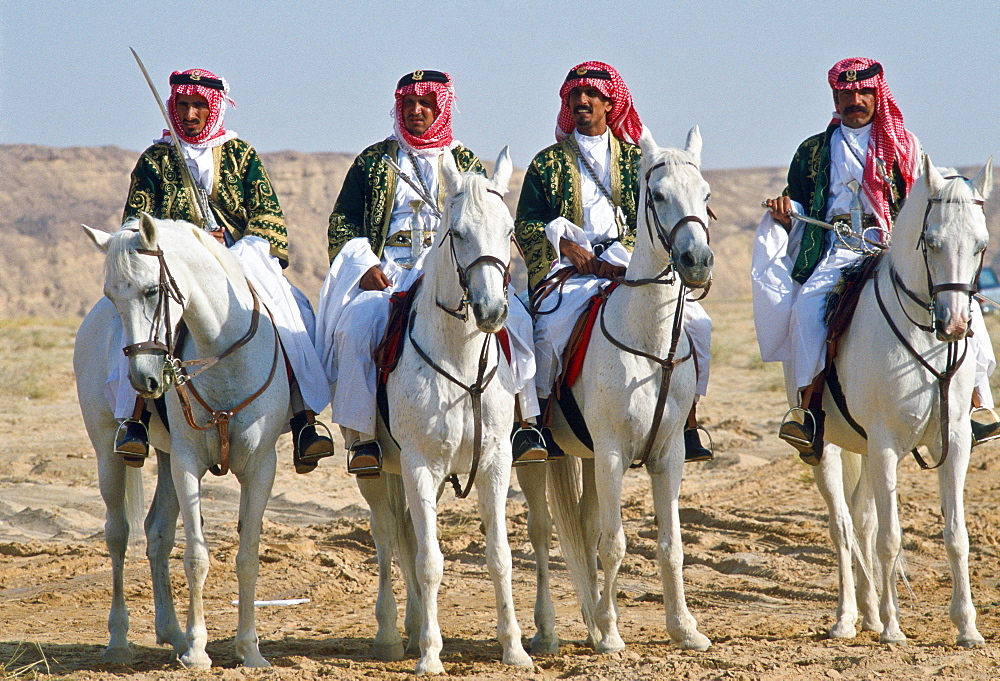 Bedouin men riding horses in the desert inSaudi Arabia.