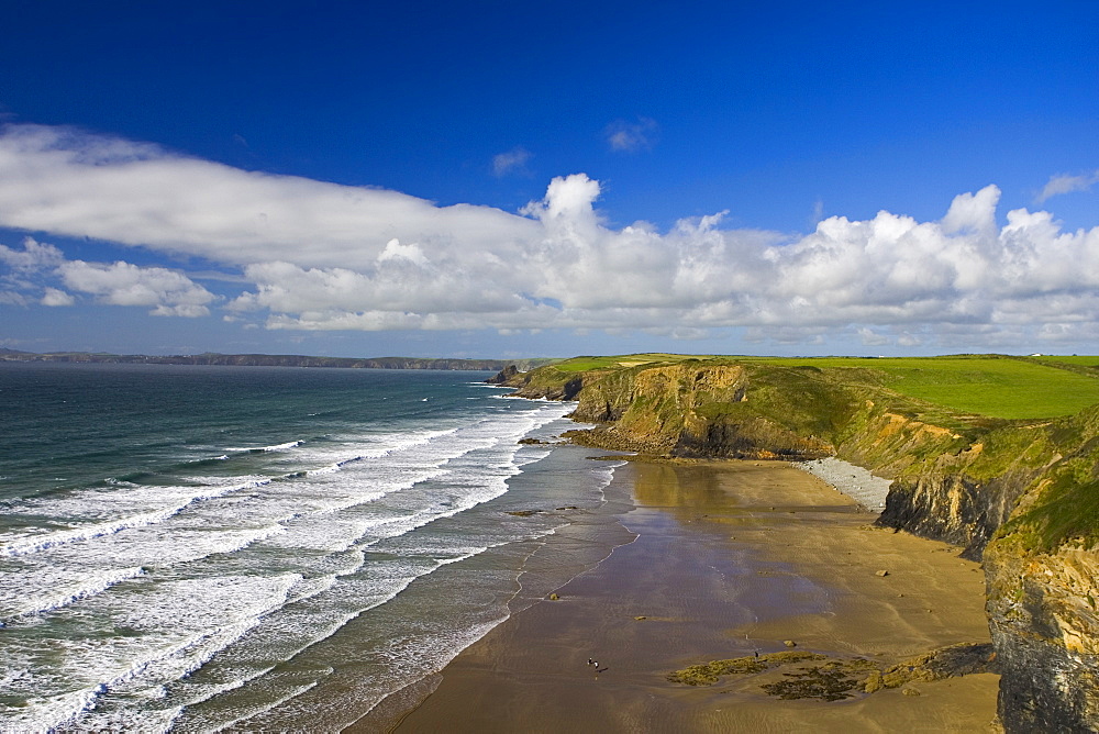 Two people walk on almost deserted DruidstoneBeach near Broad Haven, Pembrokeshire, Wales