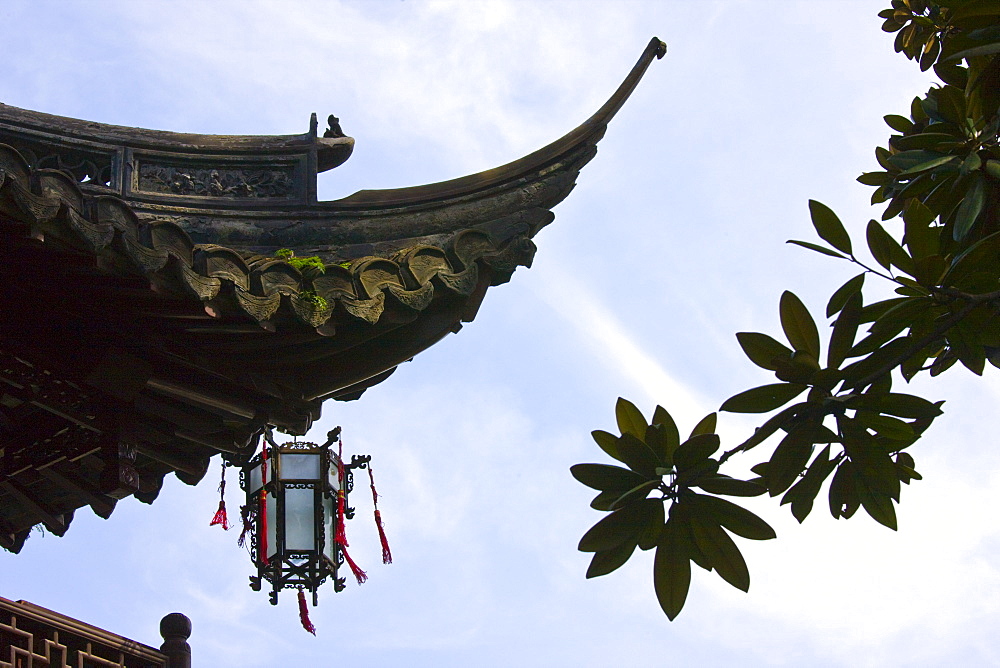 Chinese lantern hanging from traditional style roof, in the Yu Gardens, Shanghai, China