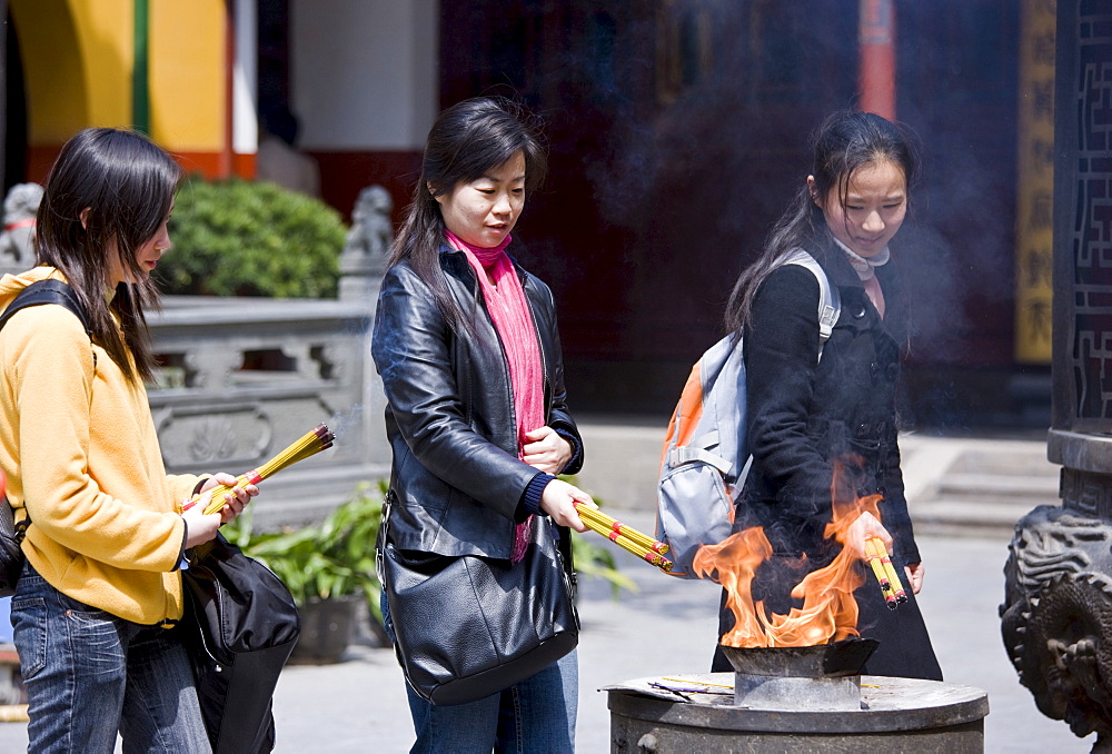 Worshippers burn incense at the Jade Buddha Temple, Shanghai, China