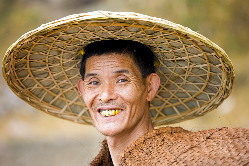 Fisherman in traditional coolie hat by the Li River, Guilin, China