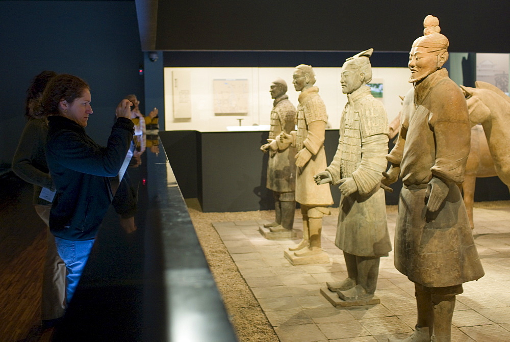 Tourists photograph Terracotta warriors on display in the Shaanxi History Museum, Xian, China