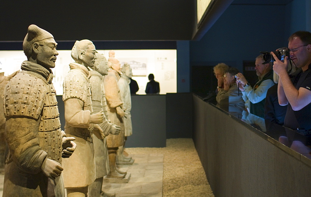 Tourists photograph Terracotta warriors on display in the Shaanxi History Museum, Xian, China