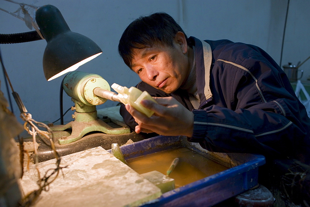 Jade craftsman at work in the Huahui Jade Factory and Showroom, Xian, China