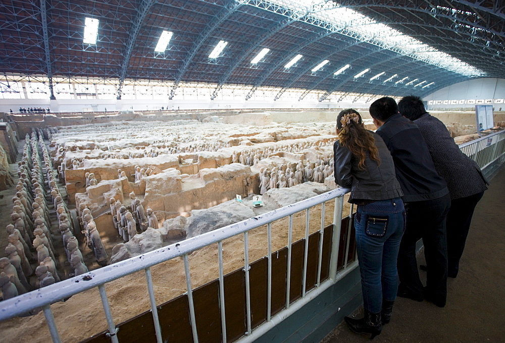 Tourists view infantry figures from the edge of Pit 1 at Qin Museum, exhibition halls of Terracotta Warriors, China